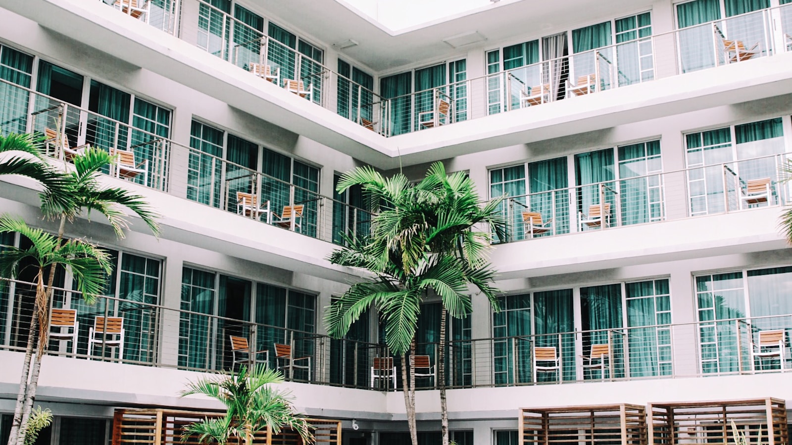 Boutique hotel building with balconies and palm trees